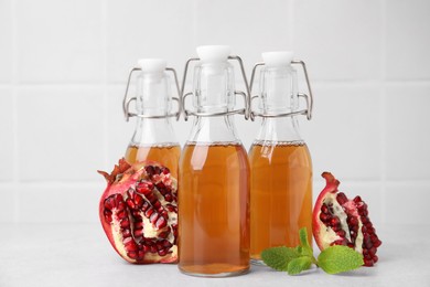 Photo of Tasty kombucha, pomegranate and mint on white table