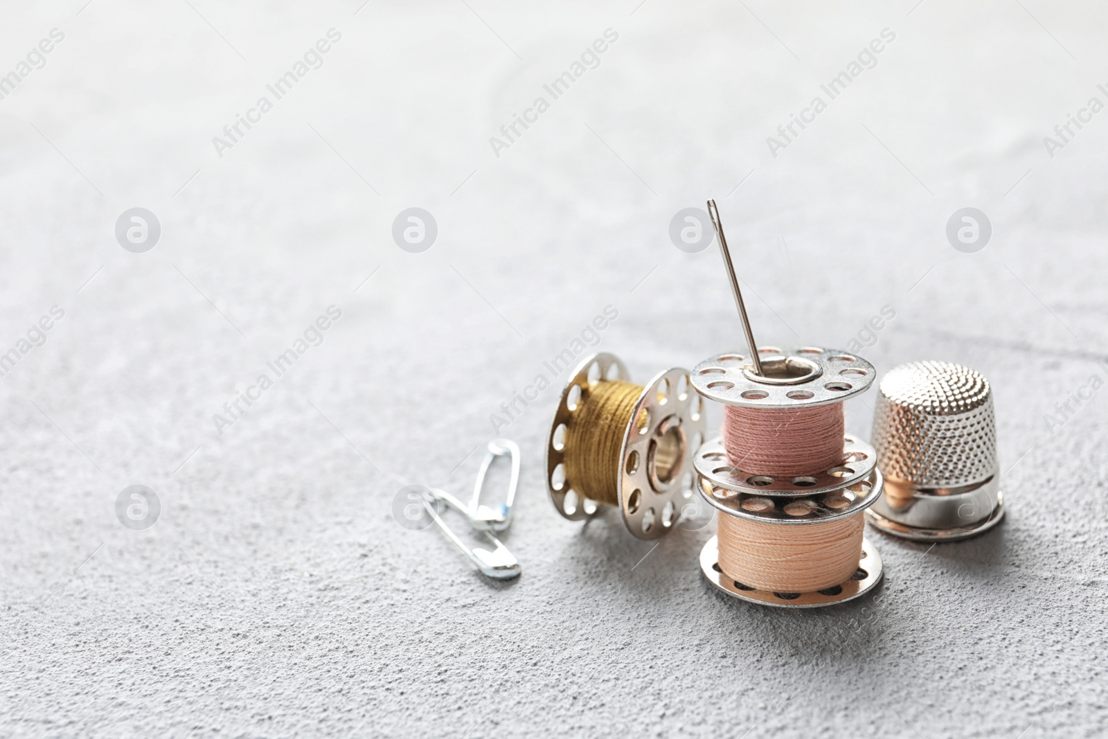 Photo of Set of tailoring accessories on grey background, closeup