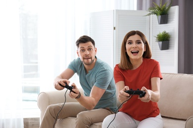 Photo of Happy couple playing video games in living room