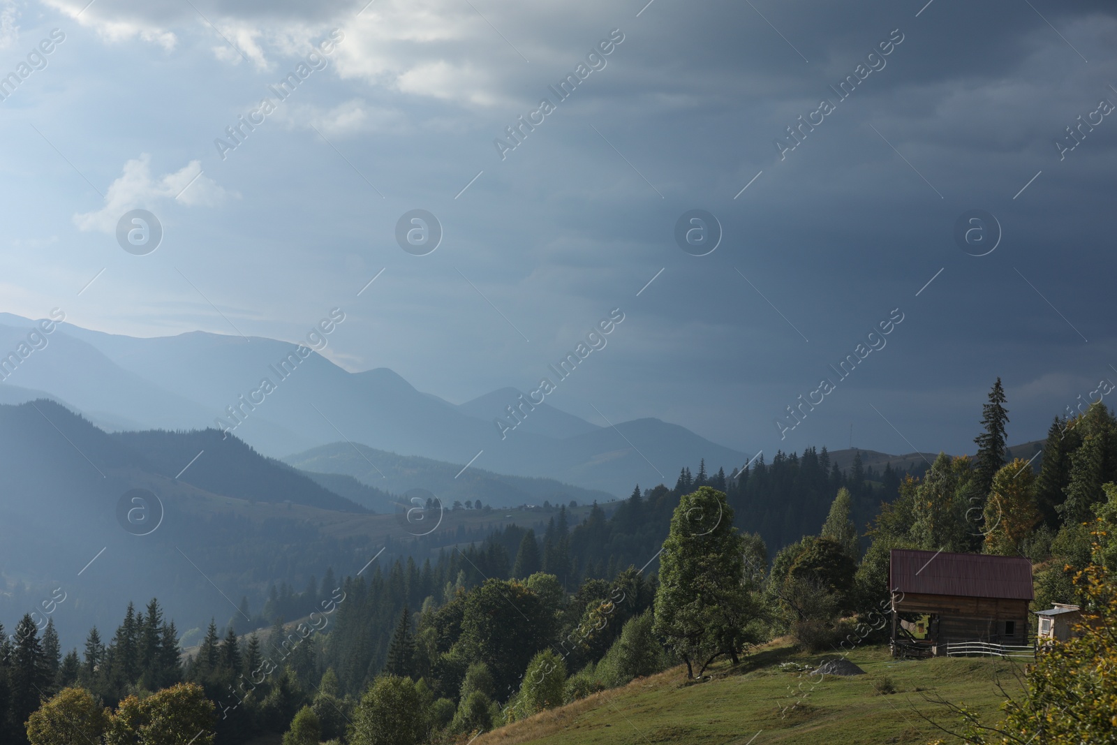 Photo of Beautiful view of wooden house on green hill in mountains