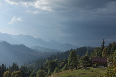Photo of Beautiful view of wooden house on green hill in mountains