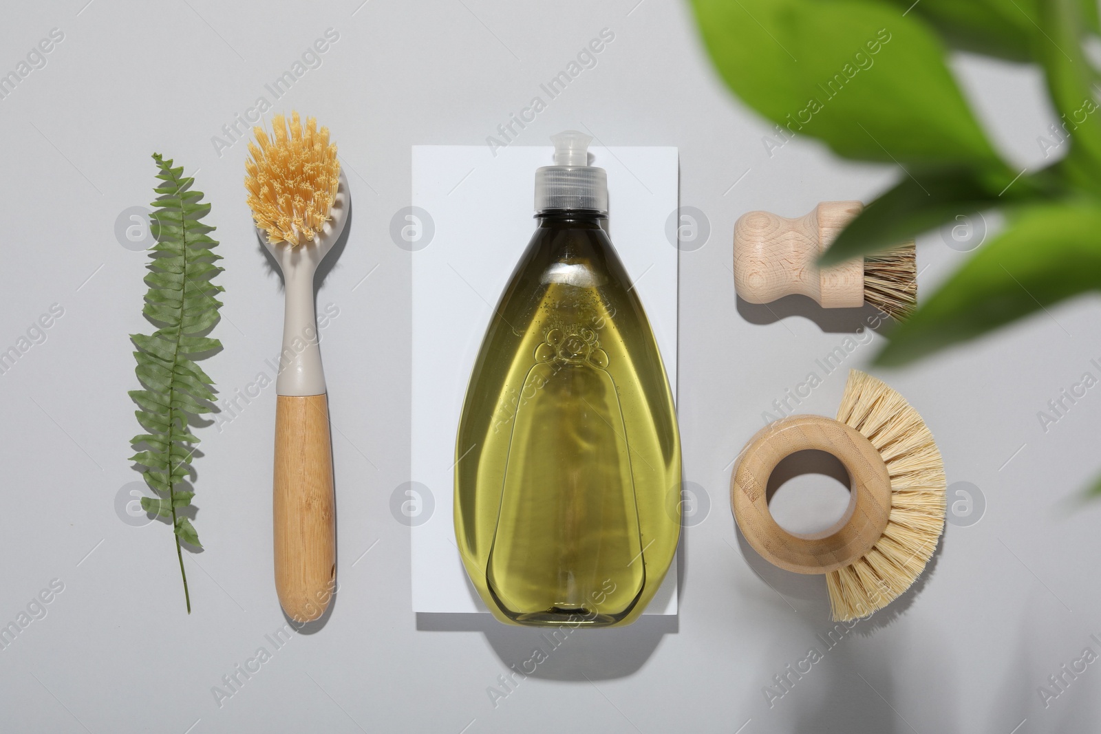 Photo of Flat lay composition with different cleaning supplies on light gray background