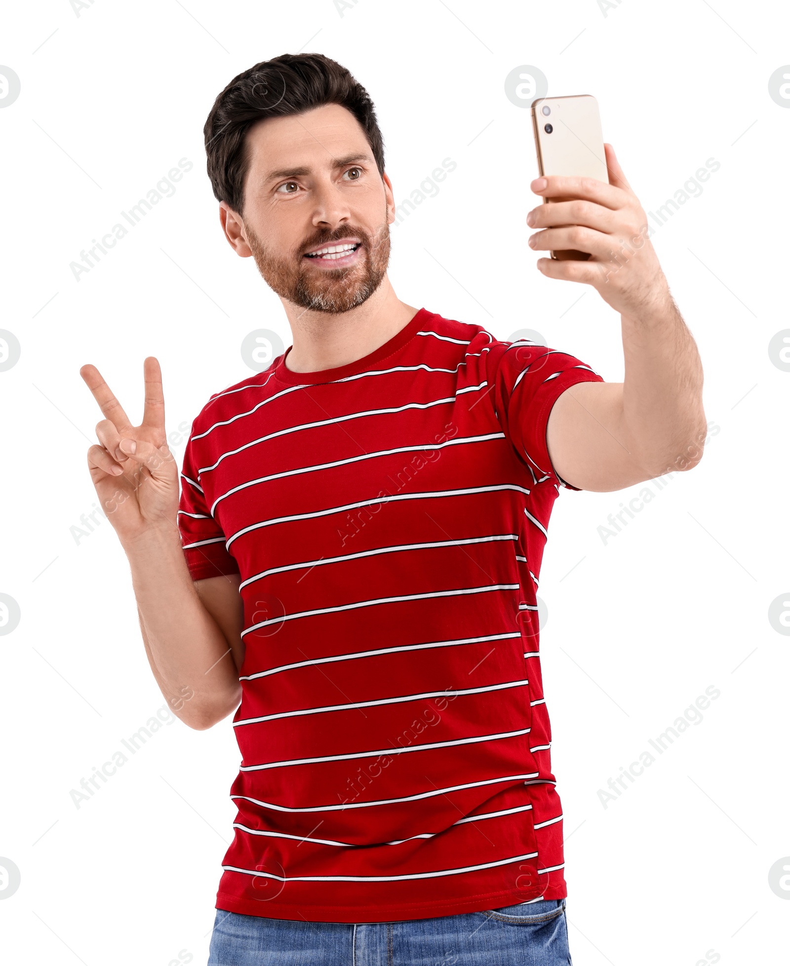 Photo of Smiling man taking selfie with smartphone and showing peace sign on white background