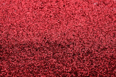 Photo of Beautiful shiny red glitter as background, closeup