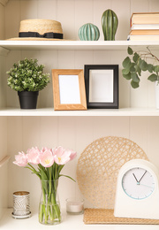 White shelving unit with plants and different decorative stuff