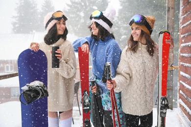 Photo of Friends with sport equipment wearing winter clothes and goggles outdoors