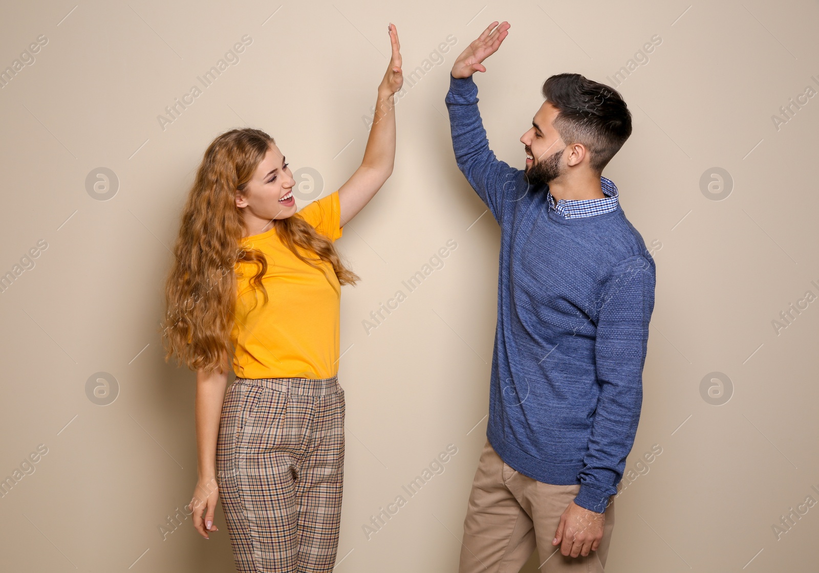 Photo of Happy young people celebrating victory on color background