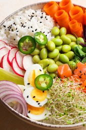 Photo of Delicious poke bowl with quail eggs, fish and edamame beans on light table, closeup