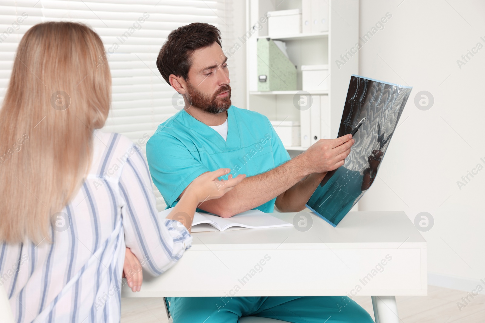 Photo of Doctor with neck MRI scan consulting patient in hospital