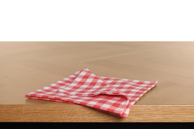 Checkered tablecloth on wooden table against white background