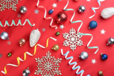 Photo of Flat lay composition with serpentine streamers and Christmas decor on red background