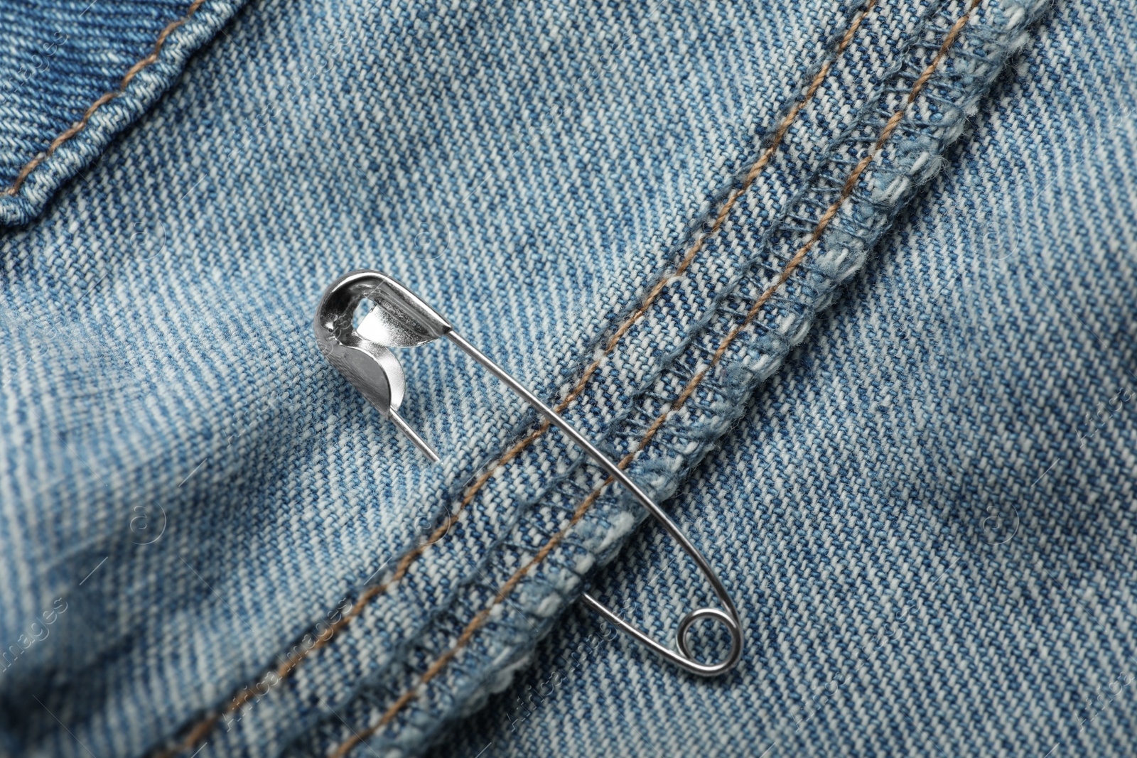 Photo of Closeup view of metal safety pin on clothing