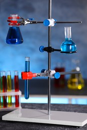 Photo of Laboratory glassware with blue liquid on retort stand indoors