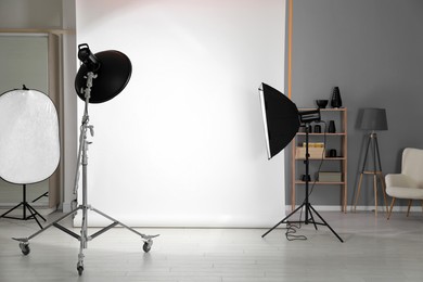 Photo of White photo background and professional lighting equipment in modern studio