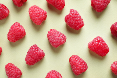 Photo of Fresh sweet ripe raspberries on light green background, flat lay