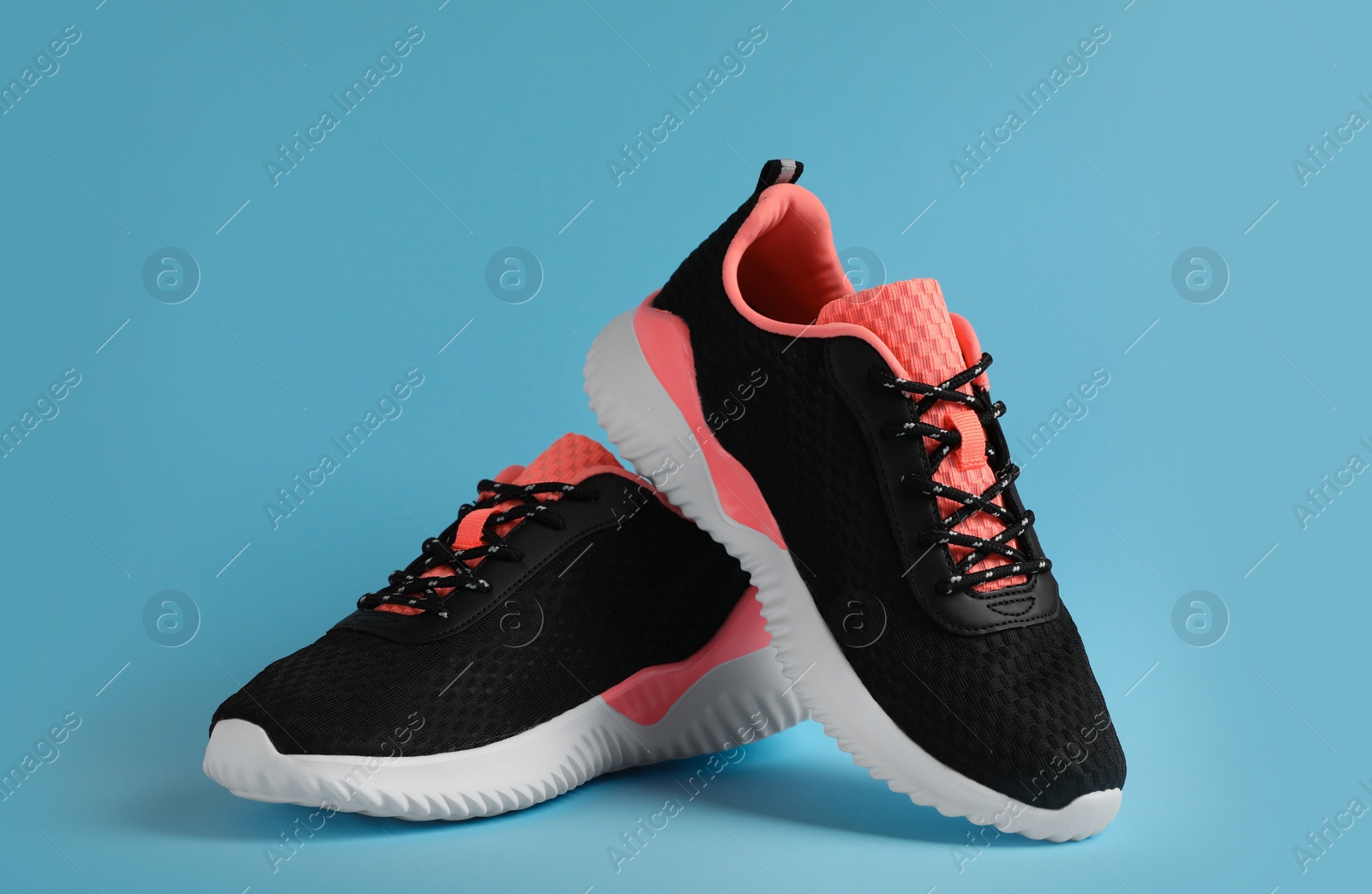 Photo of Pair of comfortable sports shoes on light blue background