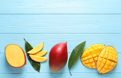 Flat lay composition with mango on color wooden background. Space for text