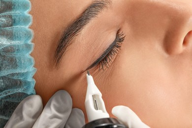 Young woman undergoing procedure of permanent eyeliner makeup, closeup