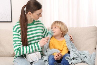 Photo of Mother helping her sick son with nebulizer inhalation at home