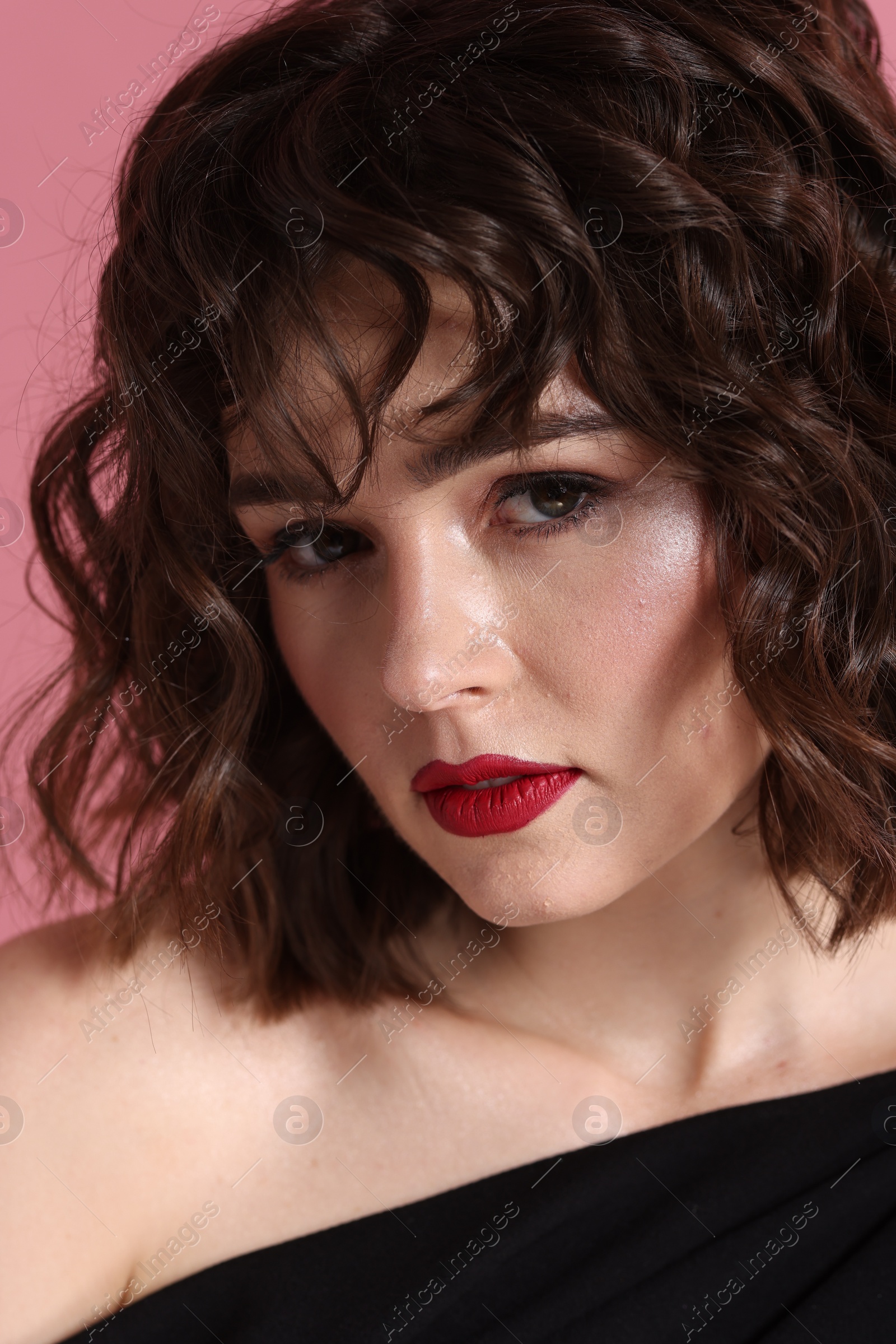 Photo of Portrait of beautiful young woman with wavy hairstyle on pink background