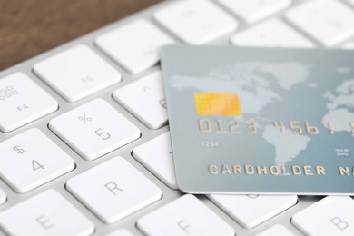 Photo of Online payment concept. Bank card on computer keyboard, closeup