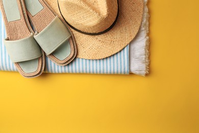 Flat lay composition with beach accessories on yellow background, space for text