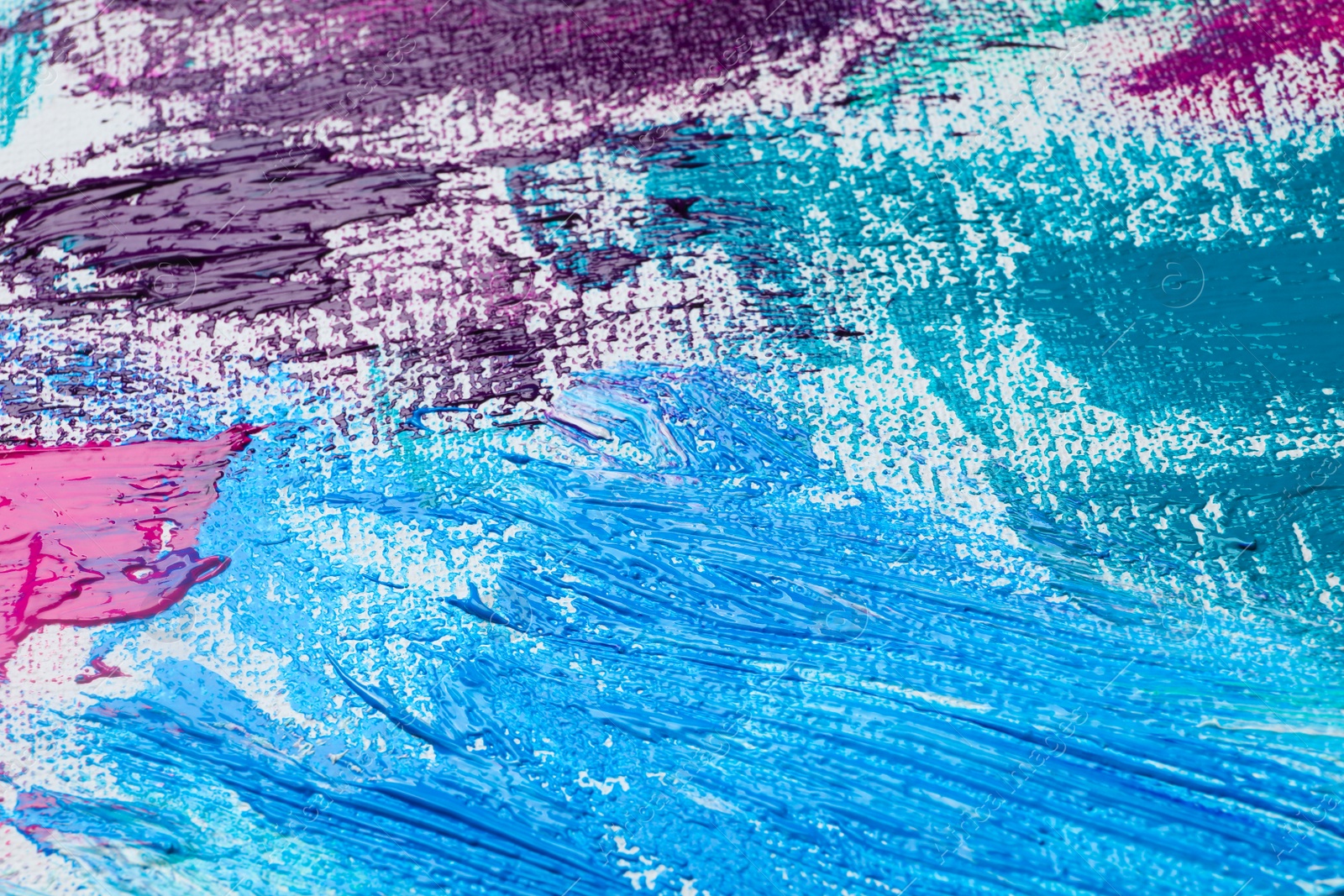 Photo of Strokes of colorful acrylic paints on white canvas, closeup