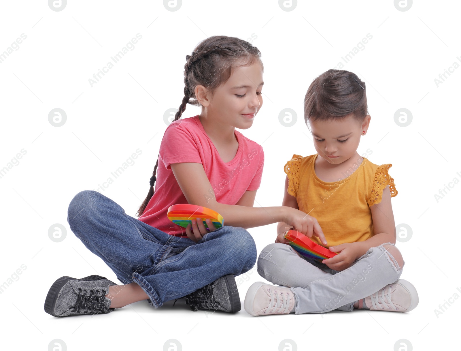 Photo of Little girls with pop it fidget toys on white background