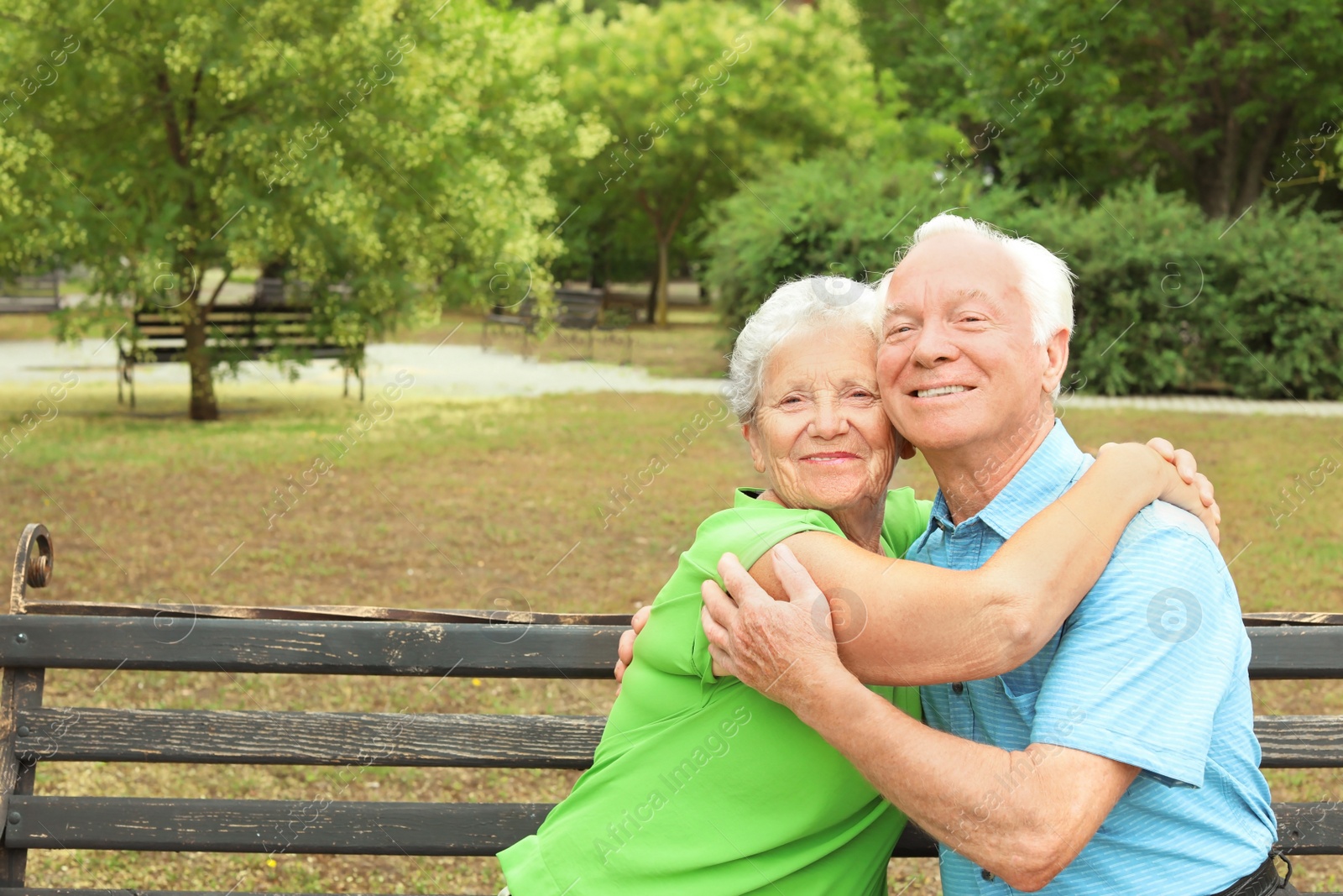 Photo of Elderly couple resting on bench in park