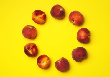 Photo of Flat lay composition with ripe peaches on yellow background, space for text