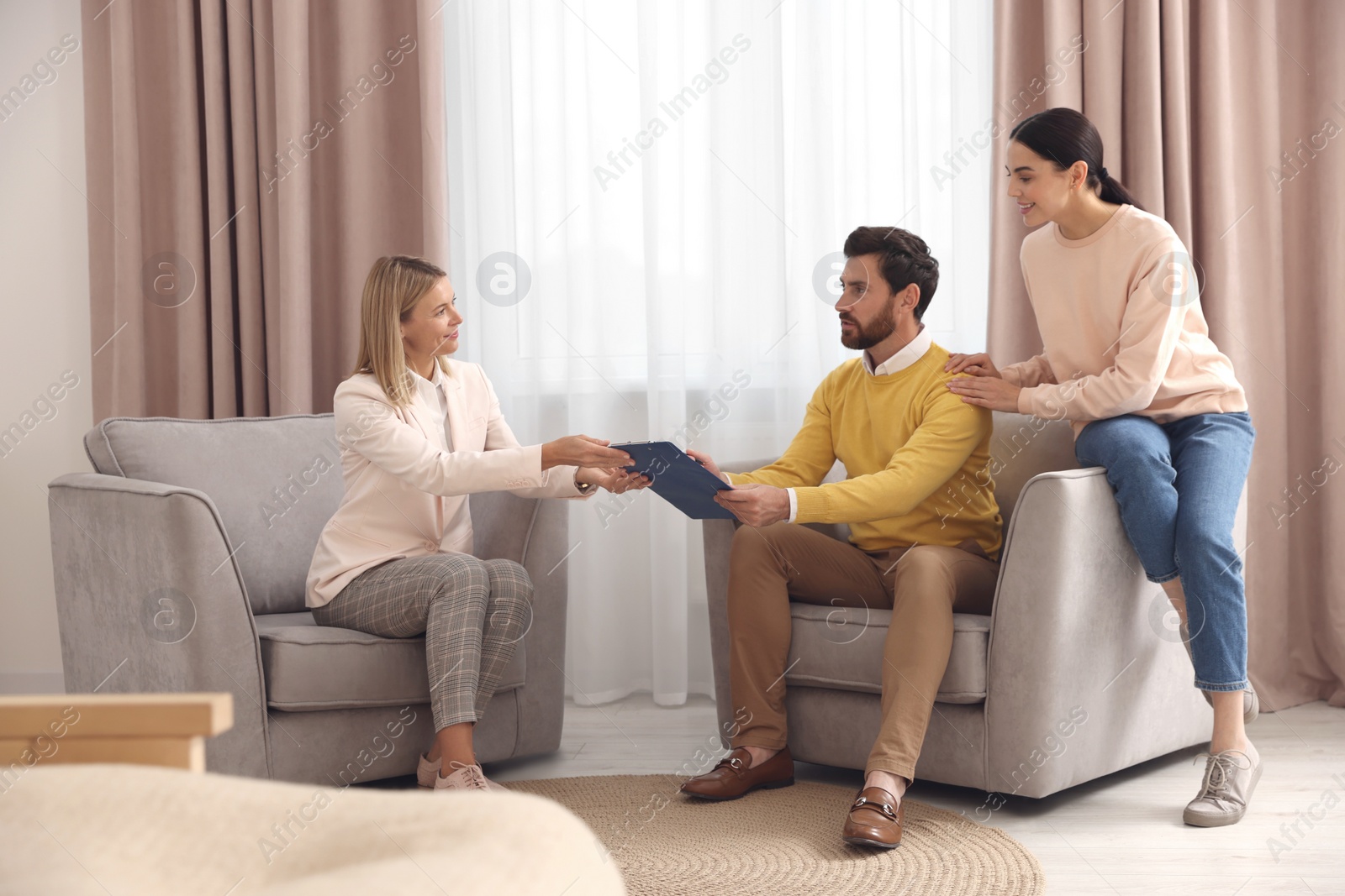 Photo of Real estate agent and couple signing contract in new apartment