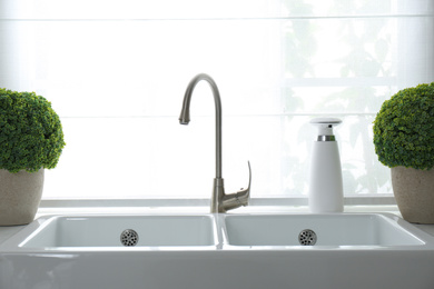 Modern double bowl sink near window in kitchen