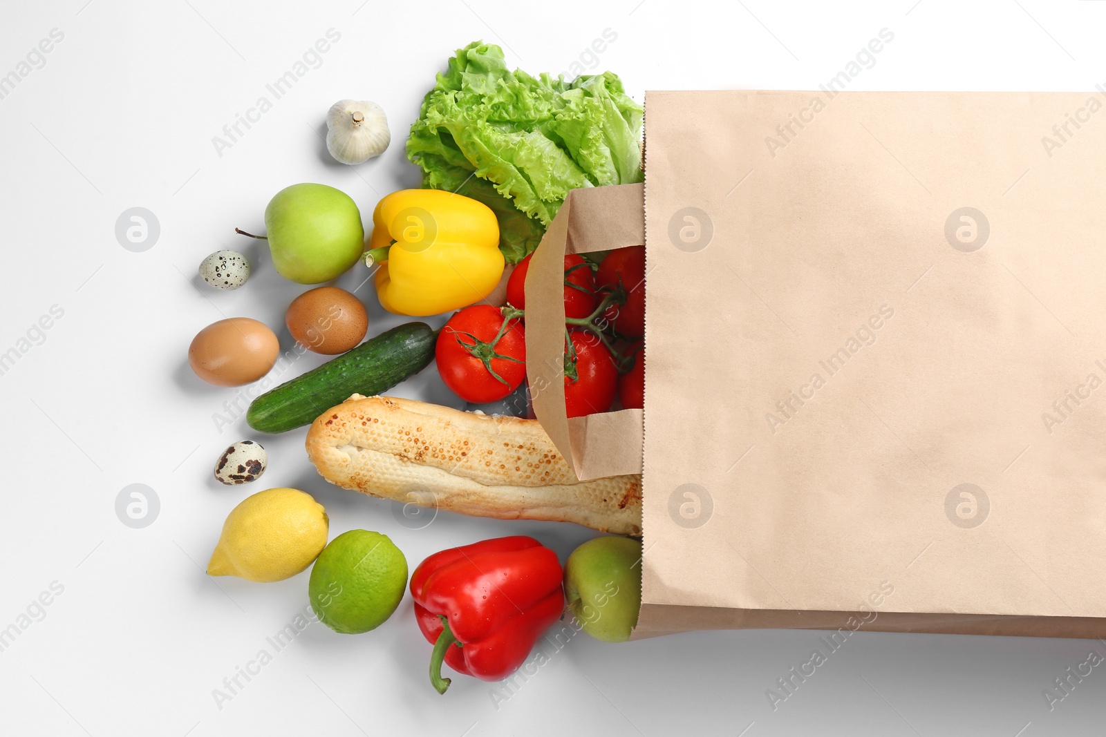 Photo of Paper bag with different groceries on white background, top view