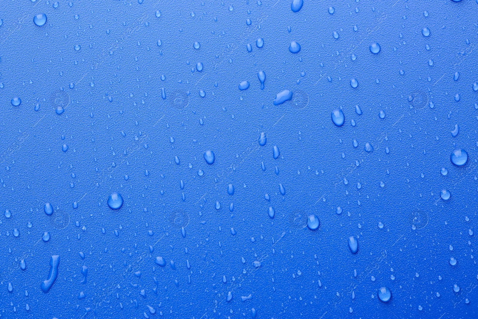 Photo of Water drops on blue background, top view