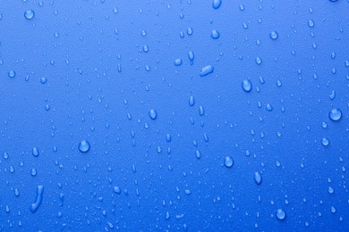 Photo of Water drops on blue background, top view