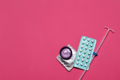 Photo of Contraception choice. Pills, condoms and intrauterine device on magenta background, flat lay. Space for text