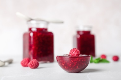 Bowl with delicious raspberry jam on table