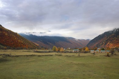Picturesque landscape with forest and mountain village on autumn day