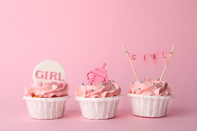 Photo of Baby shower cupcakes with toppers on pink background