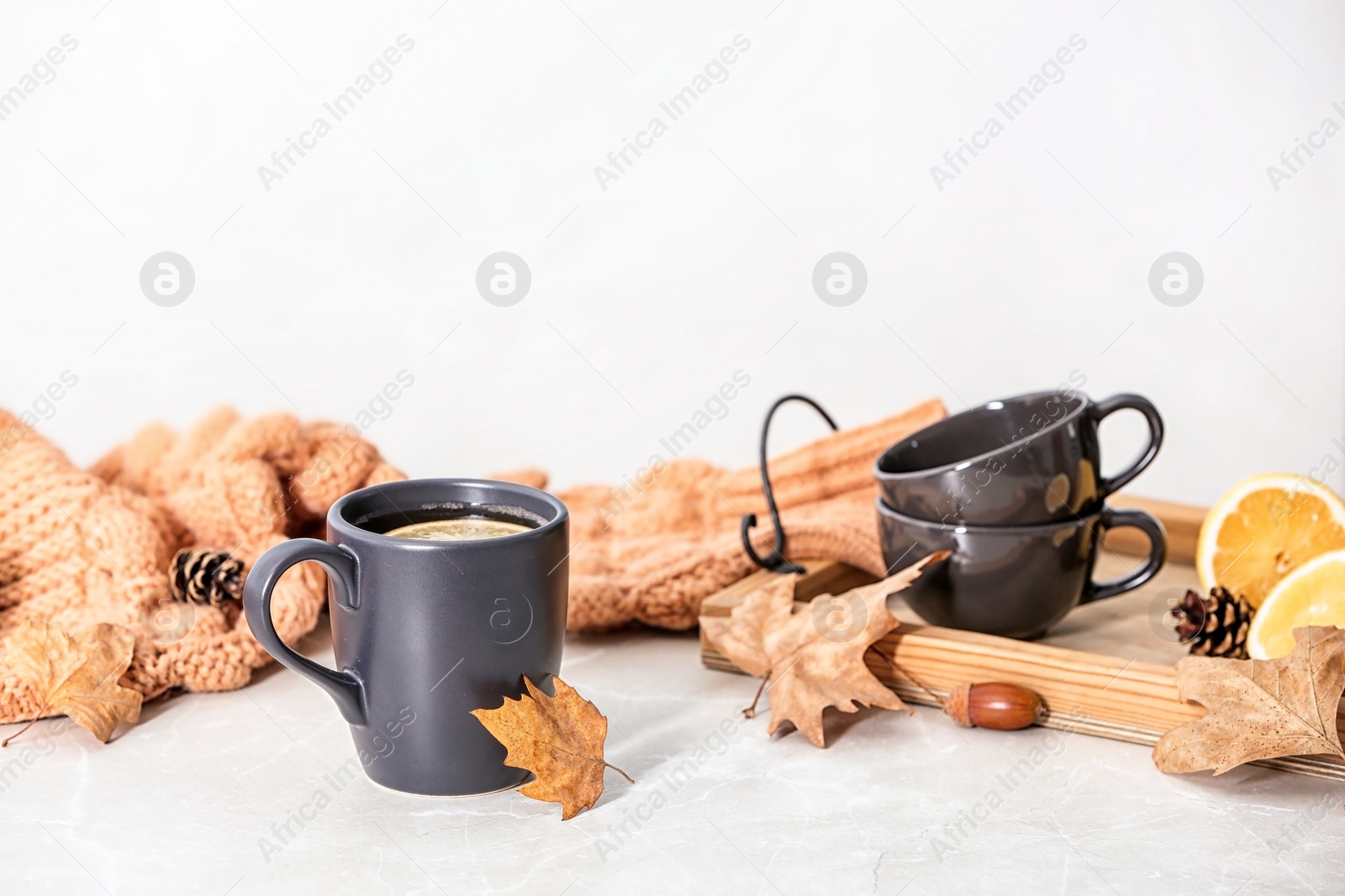 Photo of Composition with hot cozy drink and autumn leaves on table