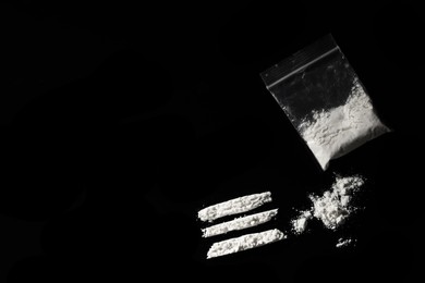 Photo of Plastic bag with hard drug on black background, flat lay. Space for text
