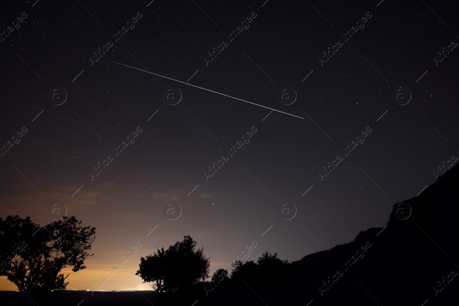 Image of Picturesque view of starry sky at night over hill