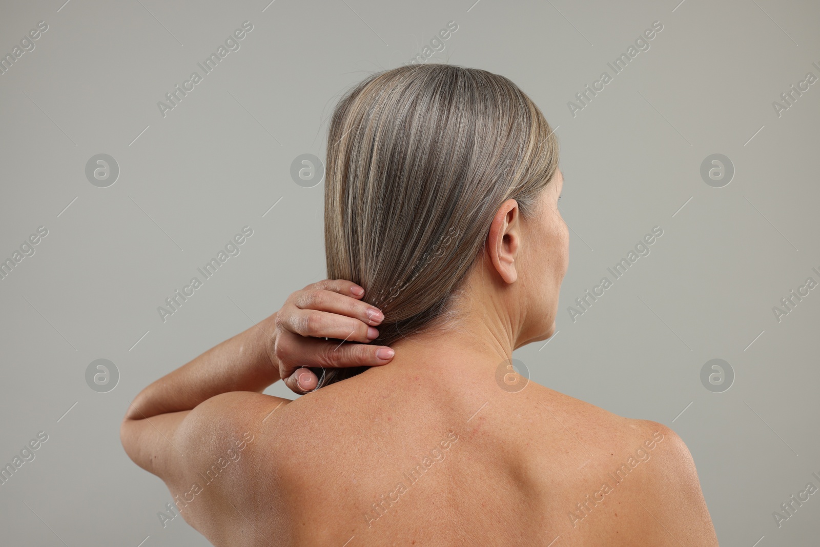 Photo of Mature woman with healthy skin on grey background