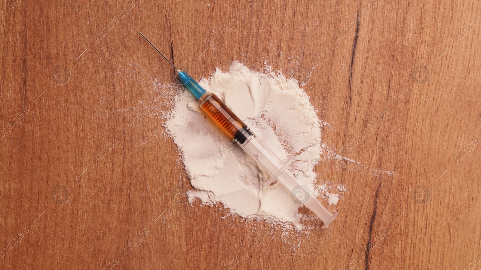 Photo of Powder and syringe on wooden table, flat lay. Hard drugs