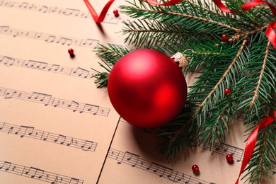 Photo of Christmas decorations on music sheets, space for text