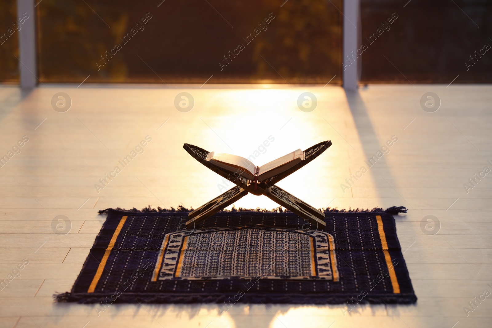 Photo of Rehal with open Quran on Muslim prayer mat indoors