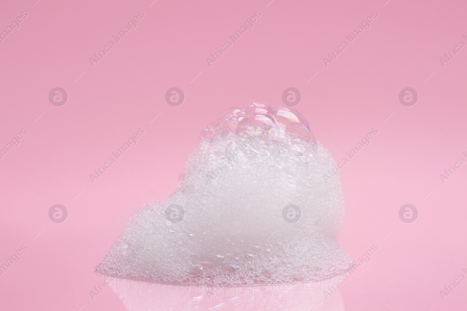 Photo of Drop of fluffy bath foam on pink background