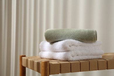 Soft towels on wicker bench indoors, space for text