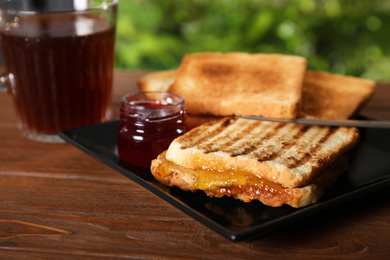 Image of Tasty sandwich with apricot jam and peanut butter for breakfast on table