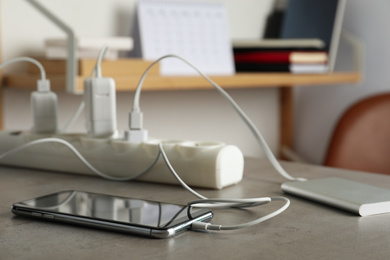 Photo of Devices charging with cable on light stone table